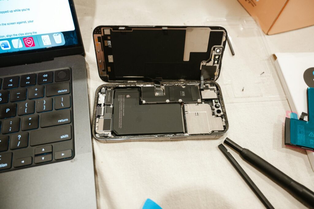 Opened smartphone with exposed battery during battery replacement work