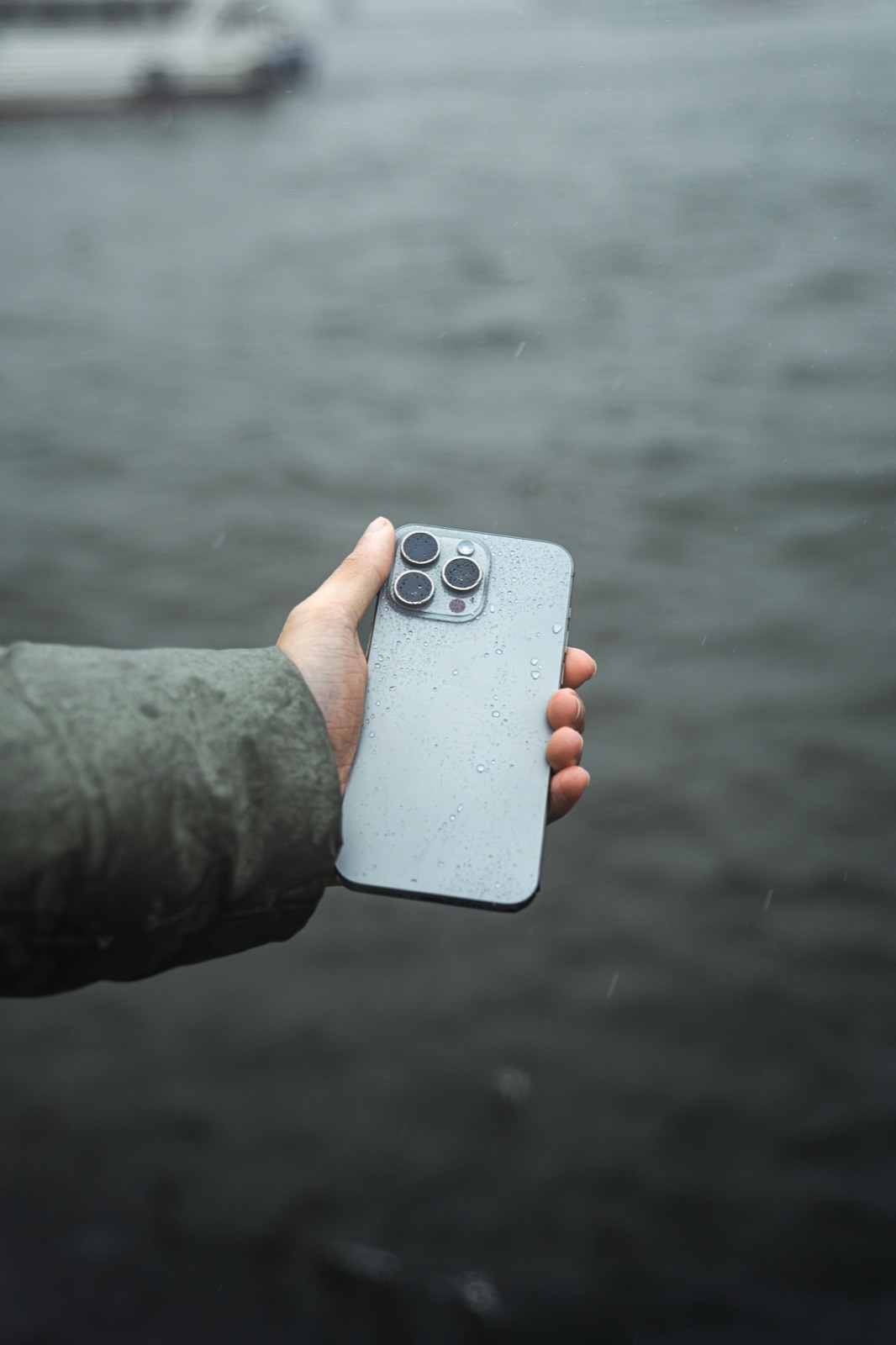 Wet smartphone in hand after rain exposure before water-damage inspection