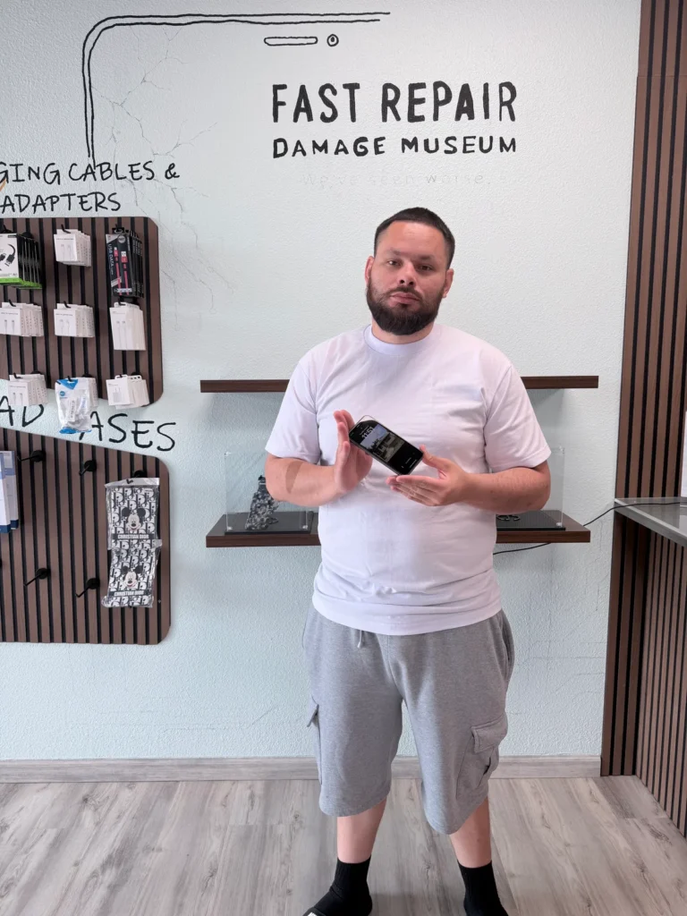 Romero holding his working iPhone 11 after a black screen repair at Fast Repair in Sacramento