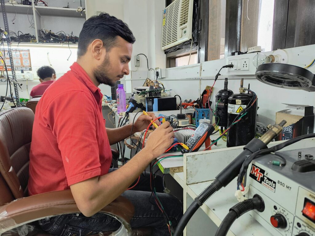Electronics technician working at a repair bench during PS5 repair diagnosis